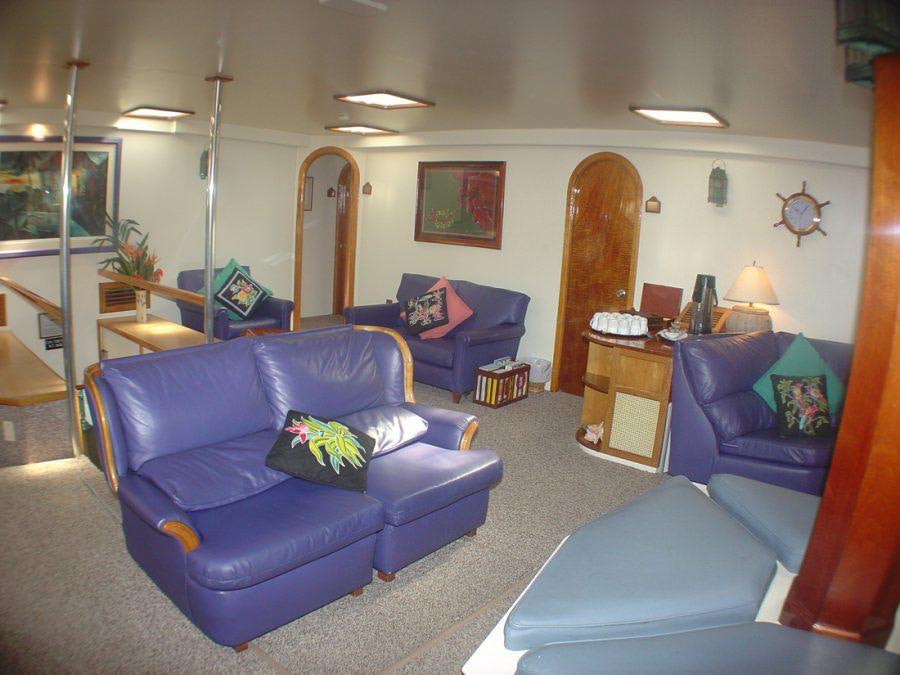a living room with blue couches aboard CUAN LAW Yacht for Charter