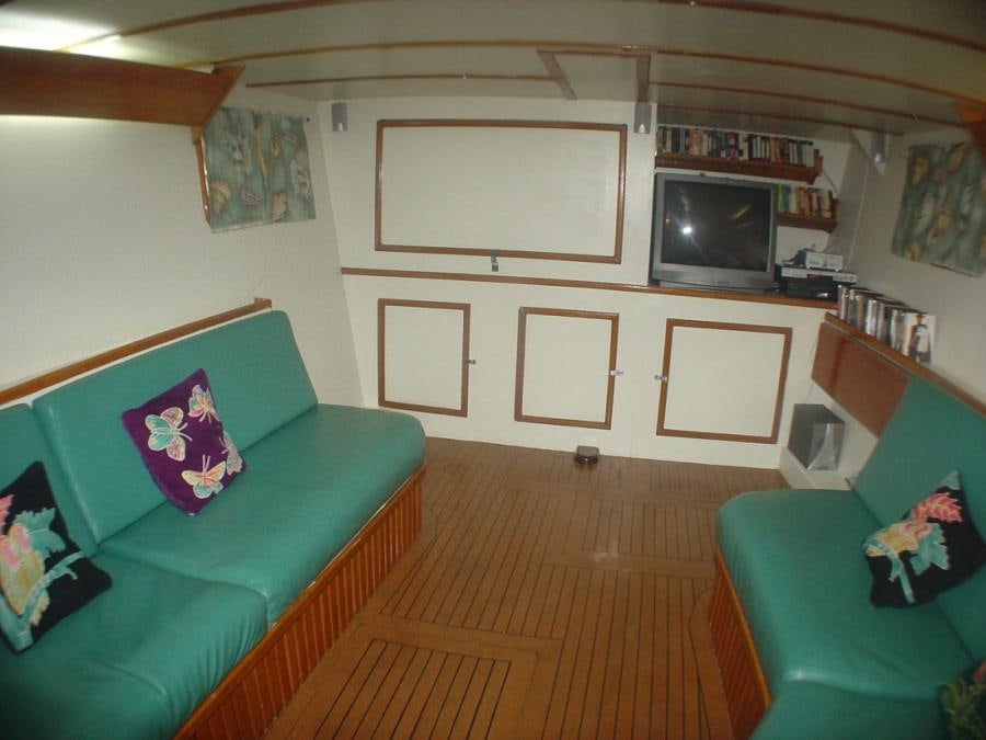 a living room with a couch and a television aboard CUAN LAW Yacht for Charter