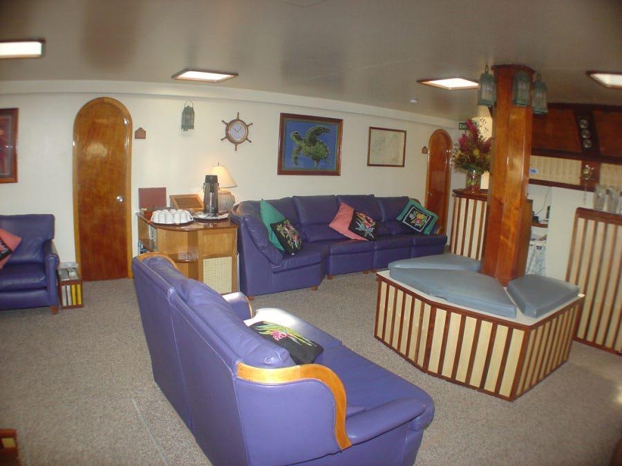 a living room with a blue couch and a coffee table aboard CUAN LAW Yacht for Charter