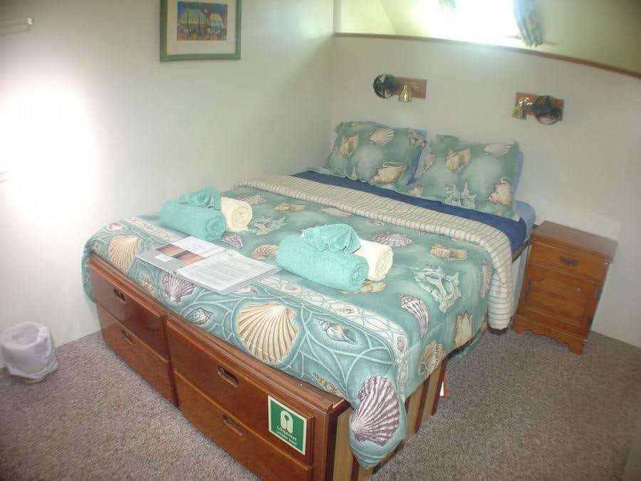 a bed with a blue comforter and a blue comforter aboard CUAN LAW Yacht for Charter