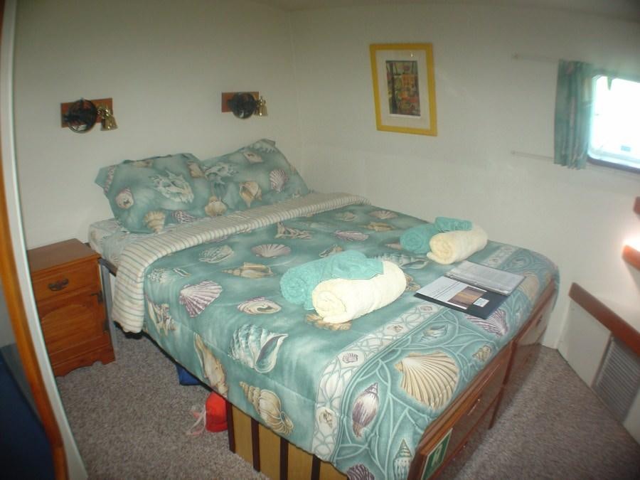 a bed with a blue sheet aboard CUAN LAW Yacht for Charter