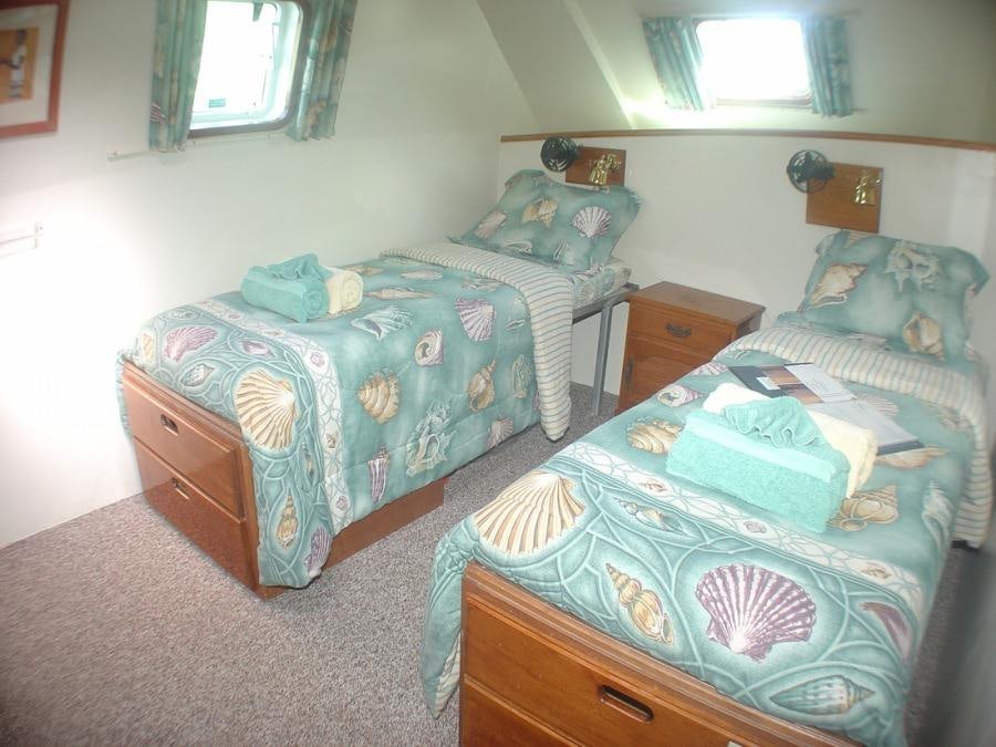 a couple of beds in a room aboard CUAN LAW Yacht for Charter
