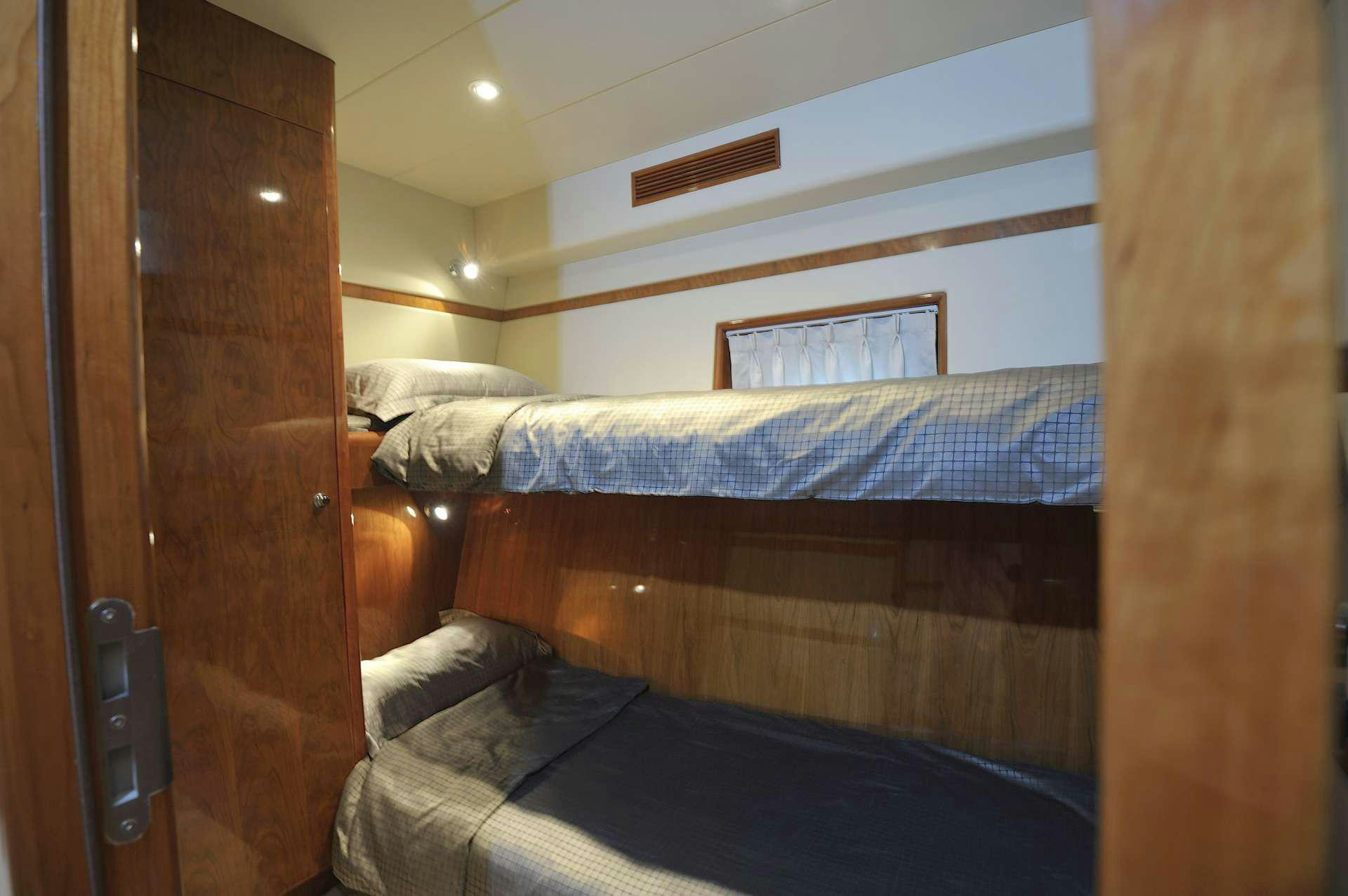 a bed with a wooden headboard aboard LADY KATHRYN Yacht for Charter