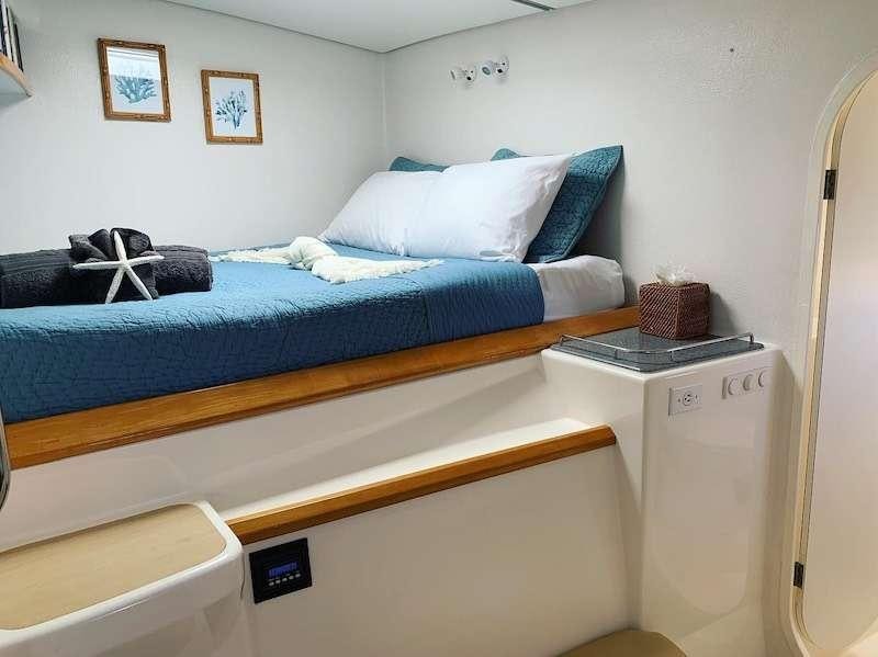 a bed with a blue comforter aboard PELICAN Yacht for Charter