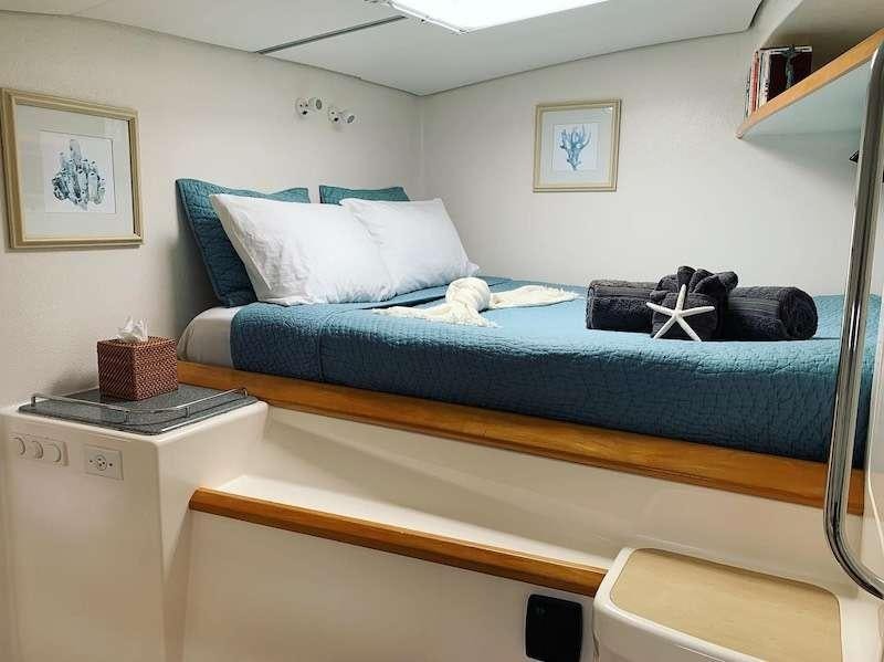 a bed with a blue bed spread aboard PELICAN Yacht for Charter