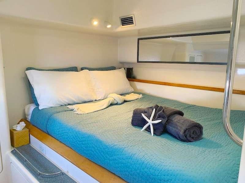 a bed with a blue comforter aboard PELICAN Yacht for Charter