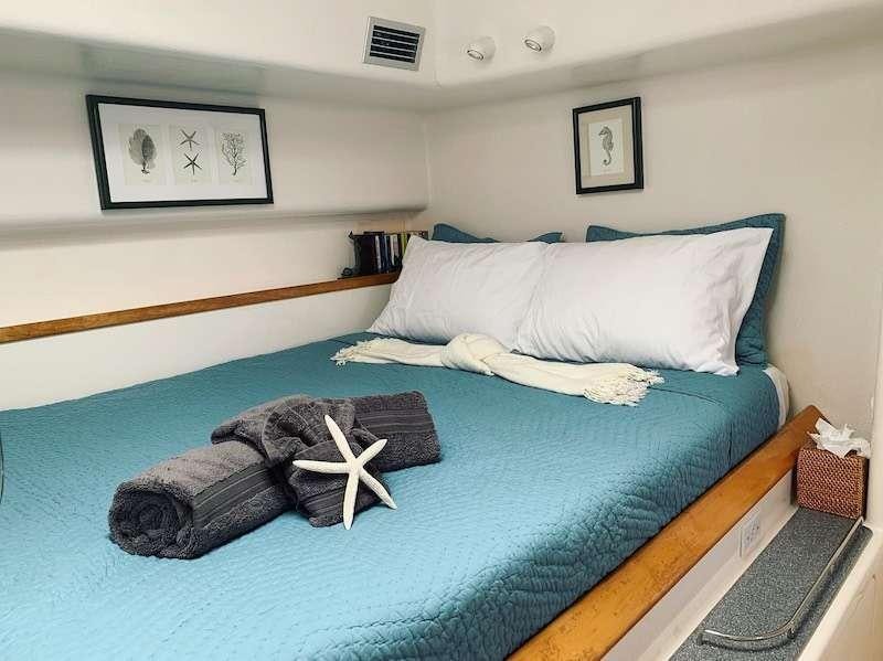 a bed with a blue comforter aboard PELICAN Yacht for Charter