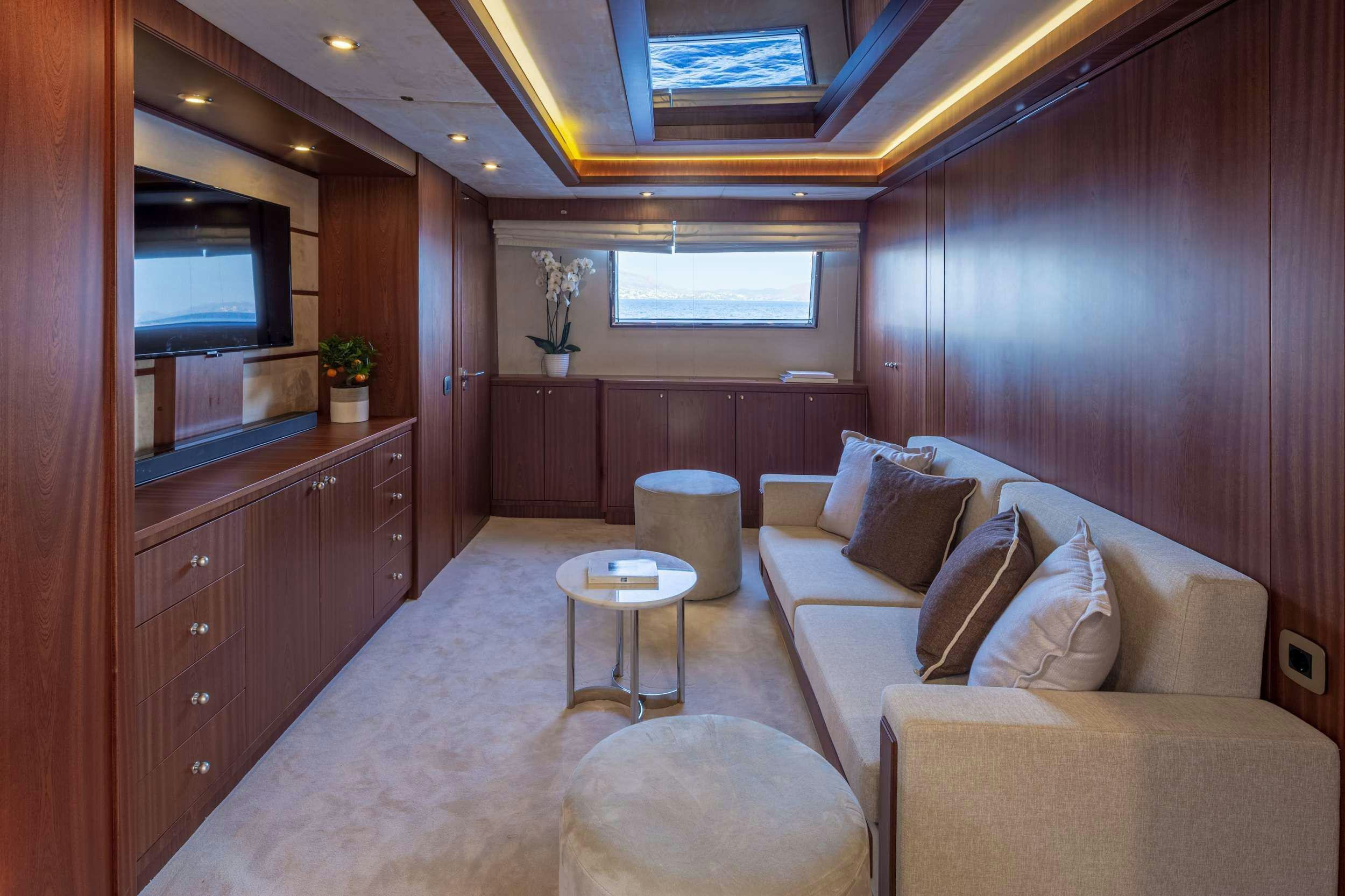 a living room with a couch and a television aboard GRACE Yacht for Charter