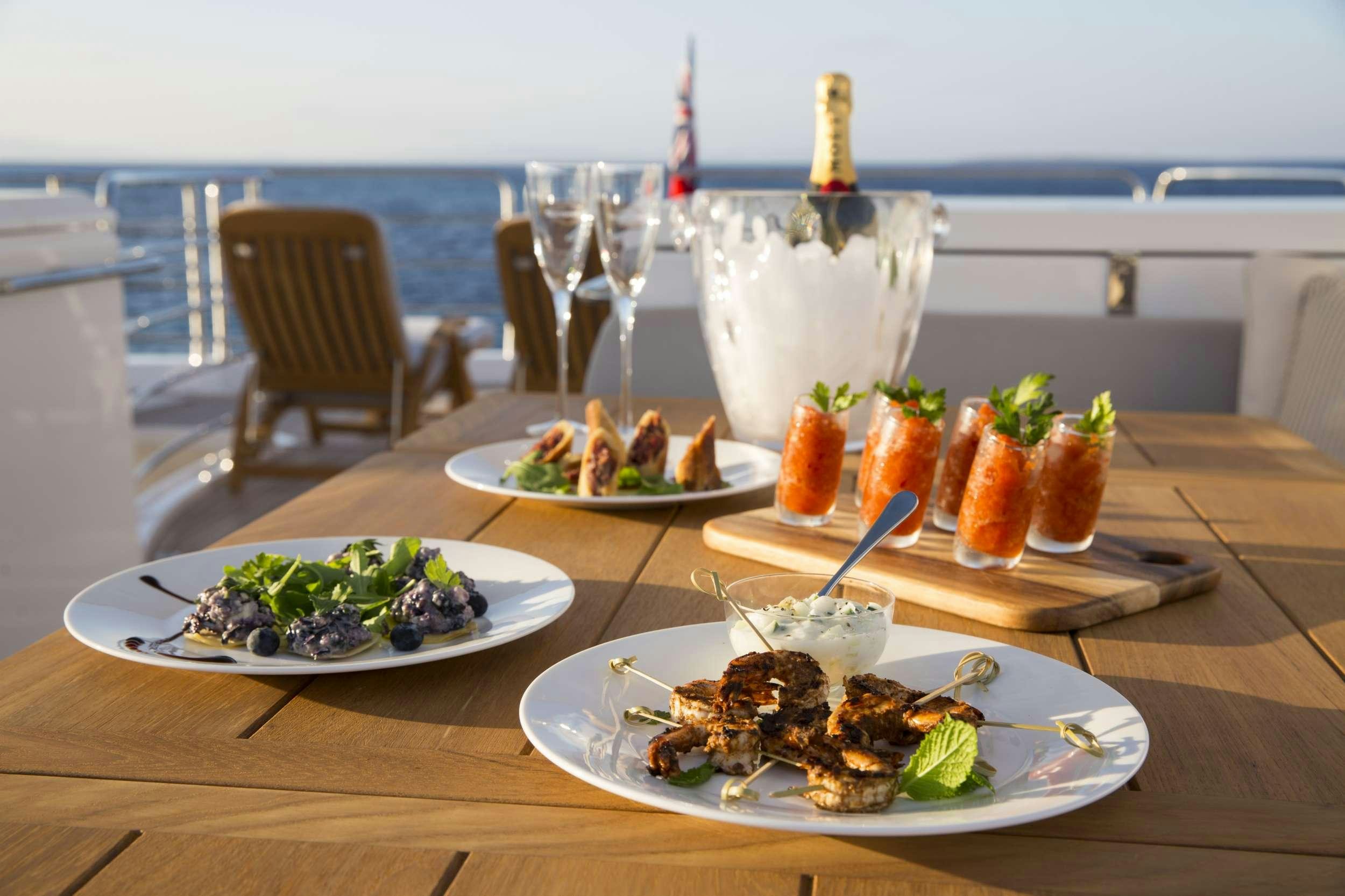 a table with plates of food and glasses on it aboard PLAY THE GAME Yacht for Charter