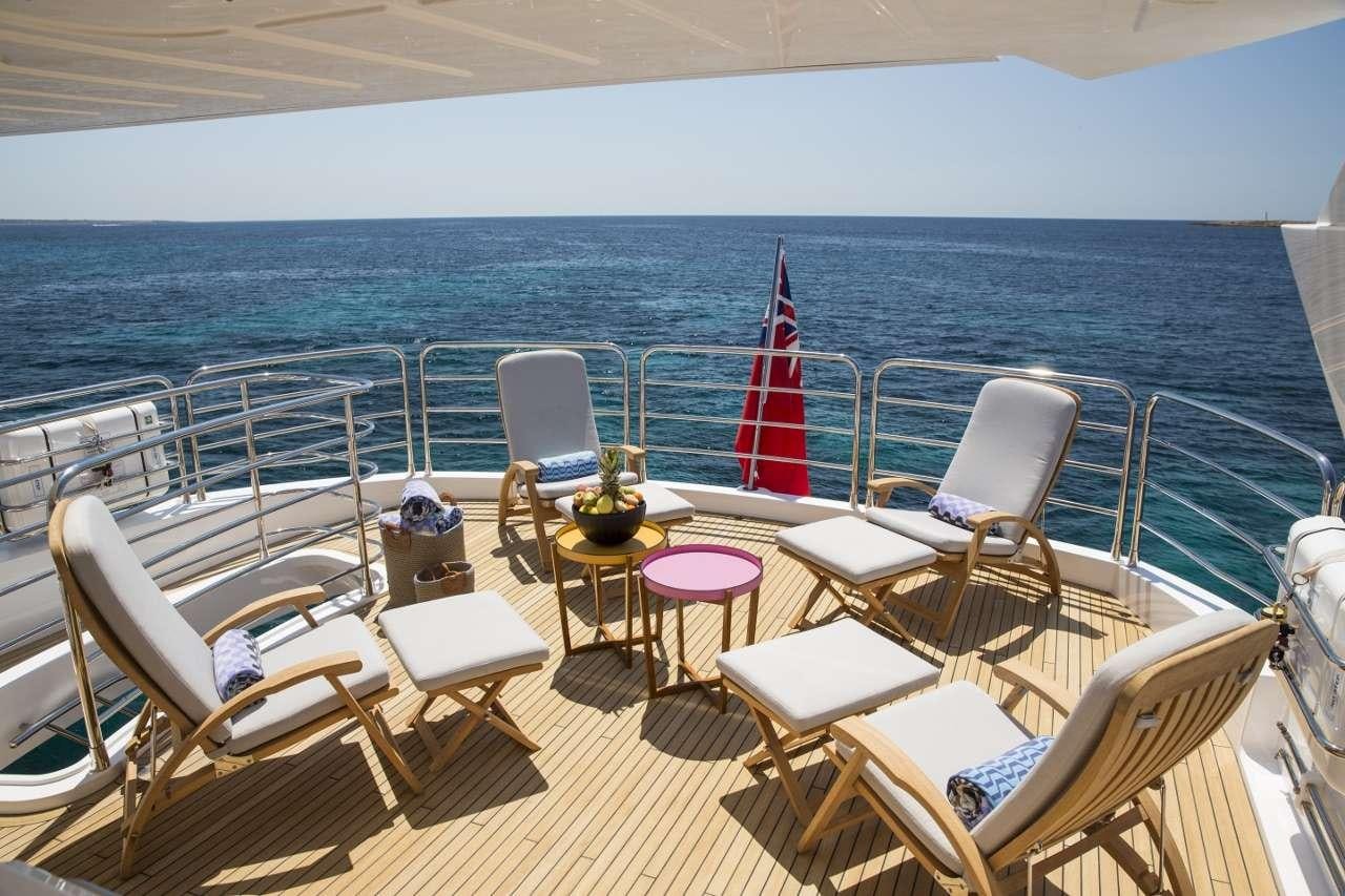 a deck with chairs and tables on it aboard PLAY THE GAME Yacht for Charter