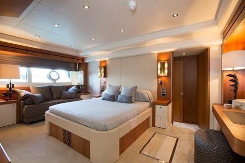 a large bedroom with a bed and a couch aboard PLAY THE GAME Yacht for Charter