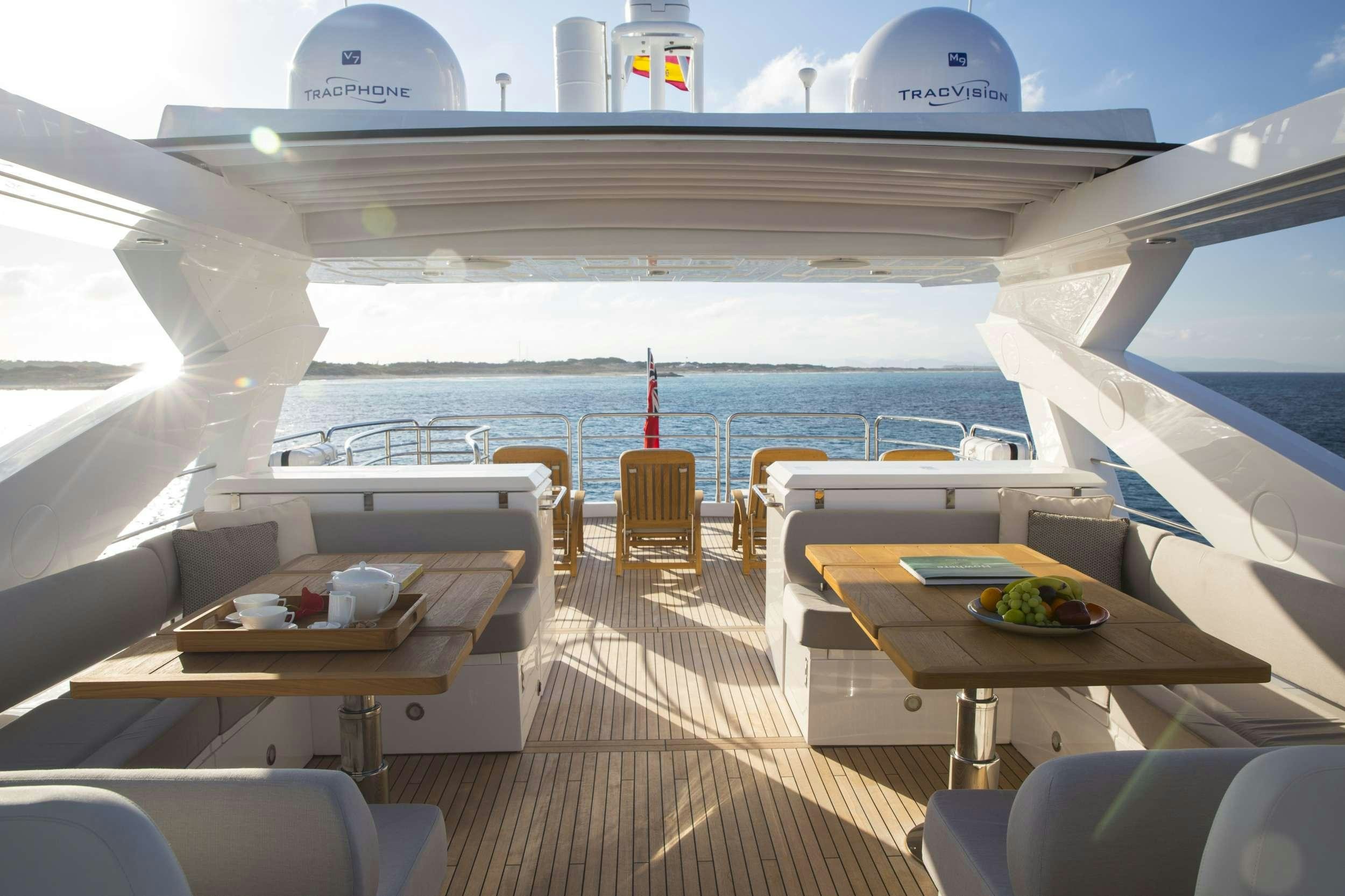 a deck with a table and chairs on it aboard PLAY THE GAME Yacht for Charter