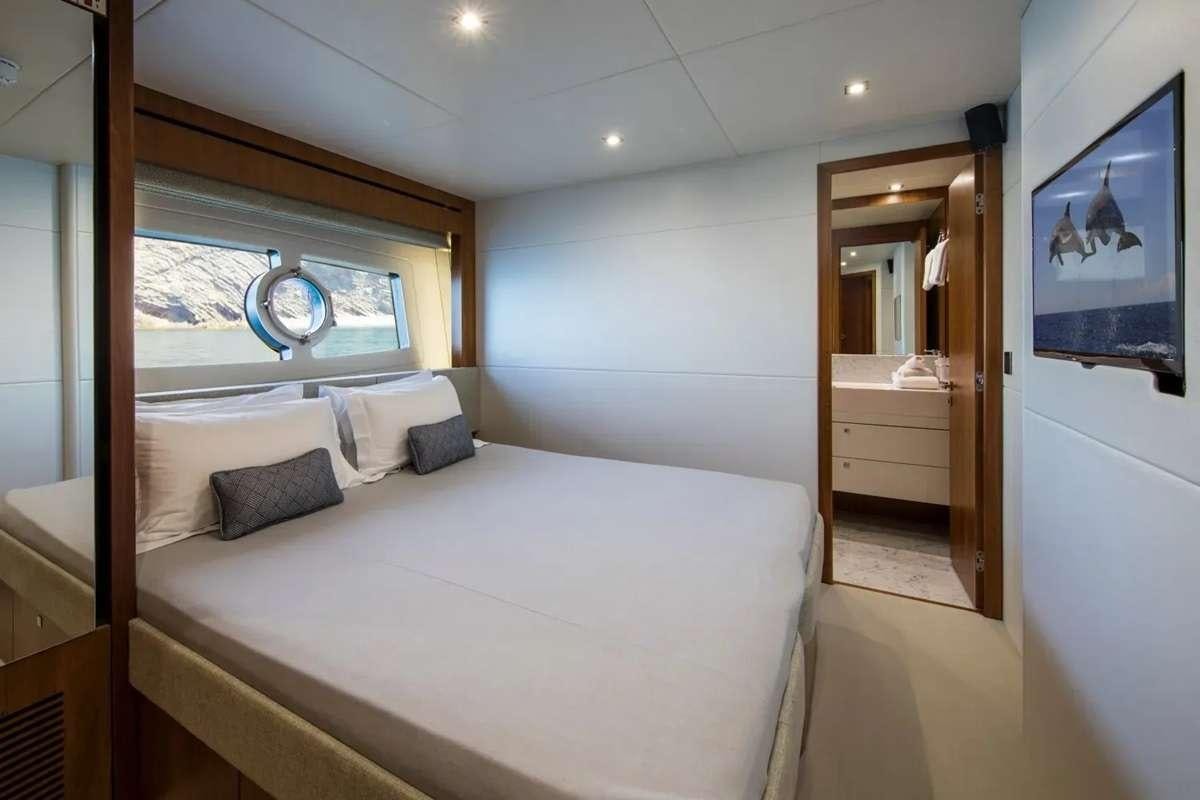 a bedroom with a bed and a mirror aboard PLAY THE GAME Yacht for Charter