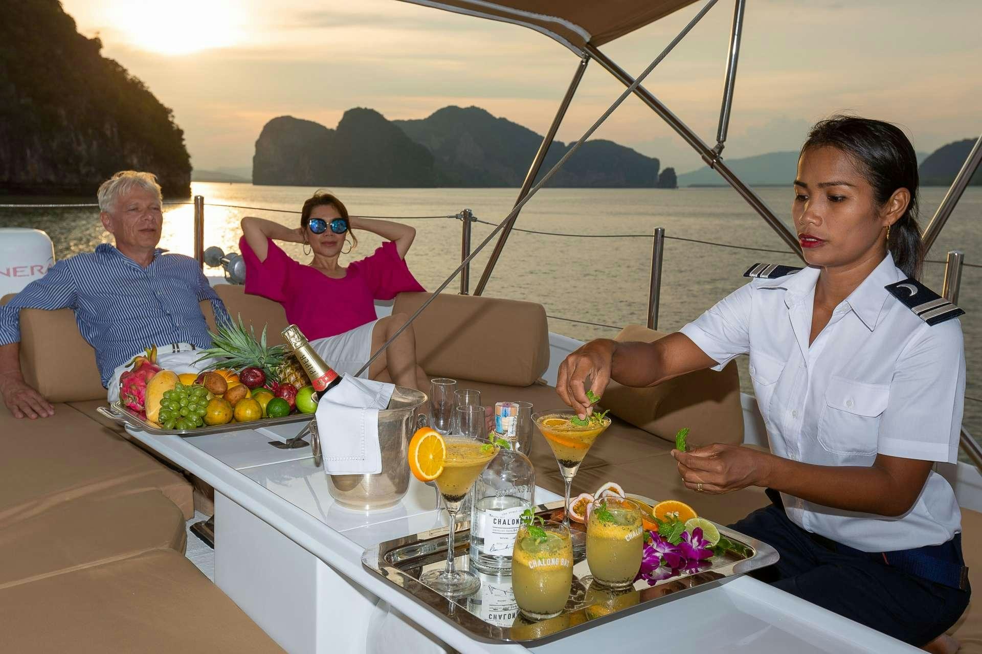 a woman sitting at a table with a man and a woman sitting at it aboard L'ORIENTALE Yacht for Charter