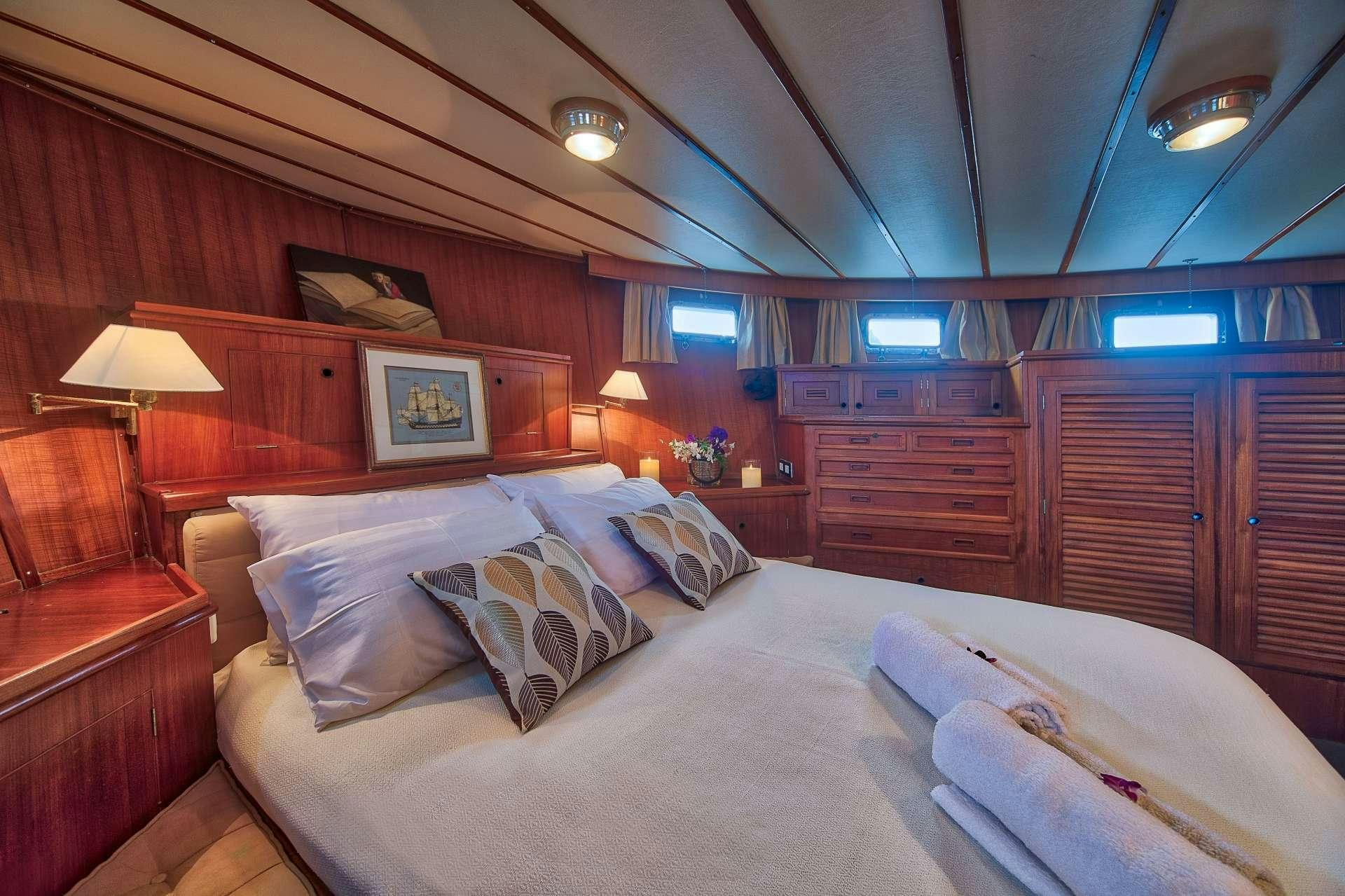 a bed with pillows and a lamp aboard L'ORIENTALE Yacht for Charter