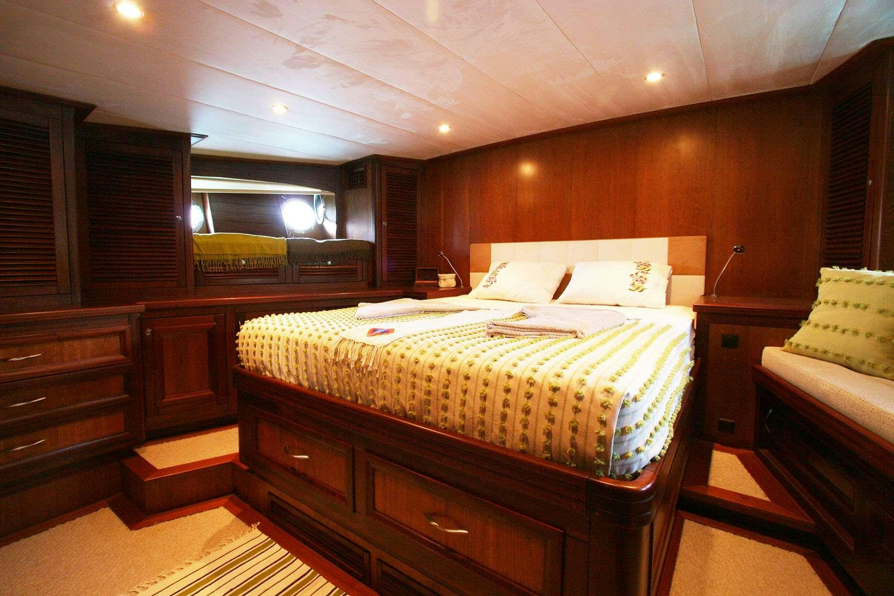 a room with a bed and a dresser aboard LADY FREYA Yacht for Charter