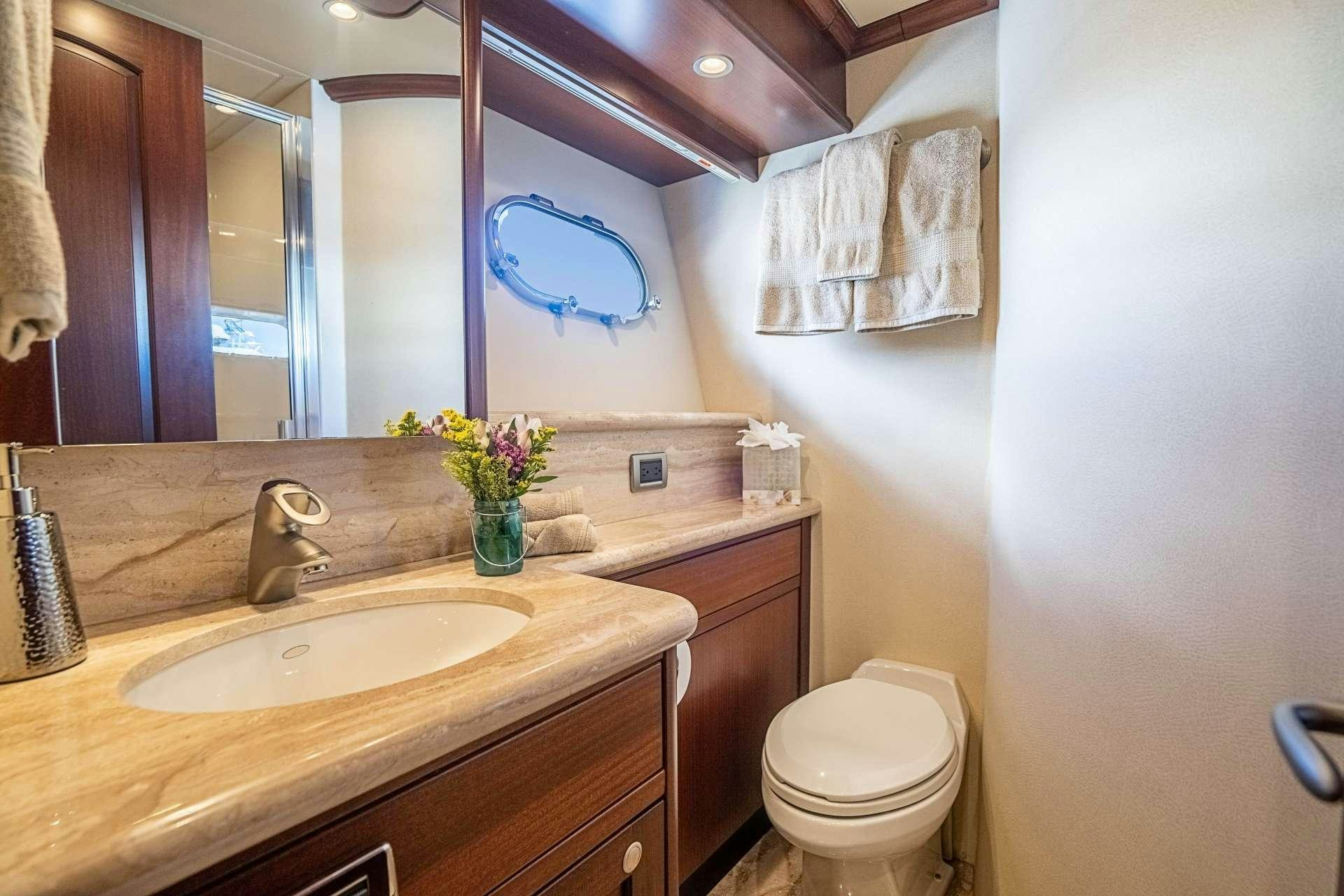 a bathroom with a sink toilet and a mirror aboard TRUE NORTH Yacht for Charter