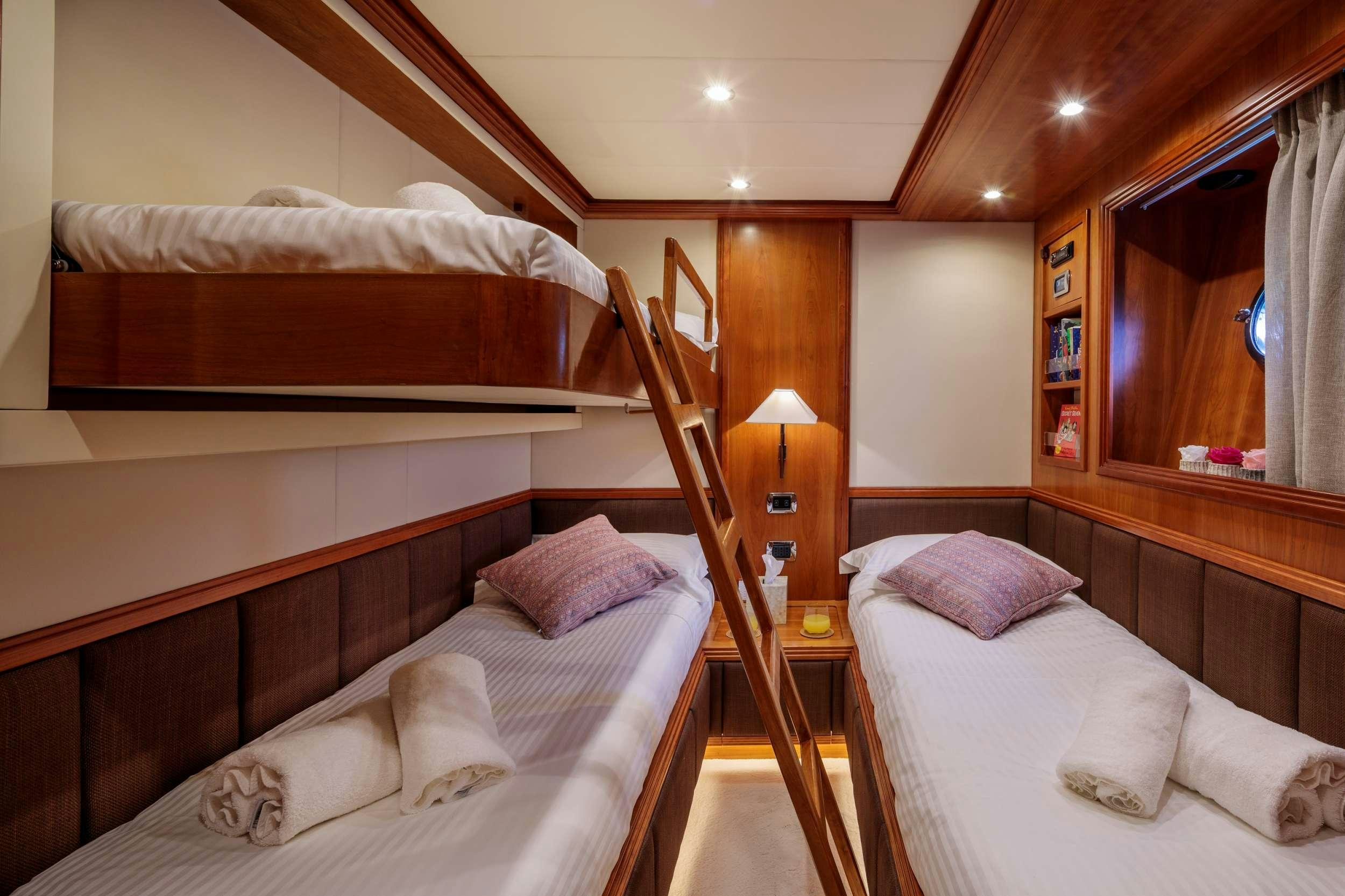 a room with a bed and a lamp aboard FREEDOM Yacht for Charter