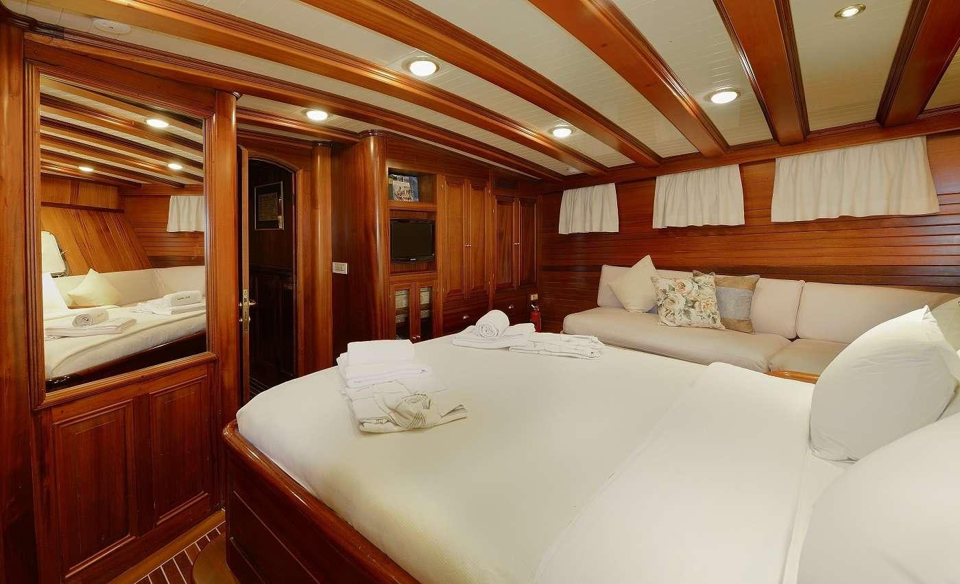 a room with a bed and a mirror aboard ECCE NAVIGO Yacht for Charter