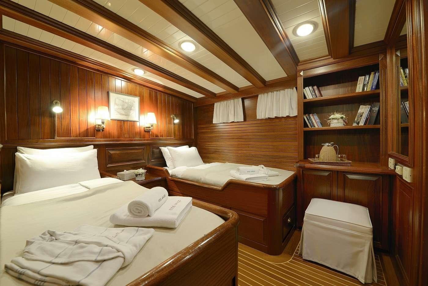 a room with a bed and a bookcase aboard ECCE NAVIGO Yacht for Charter
