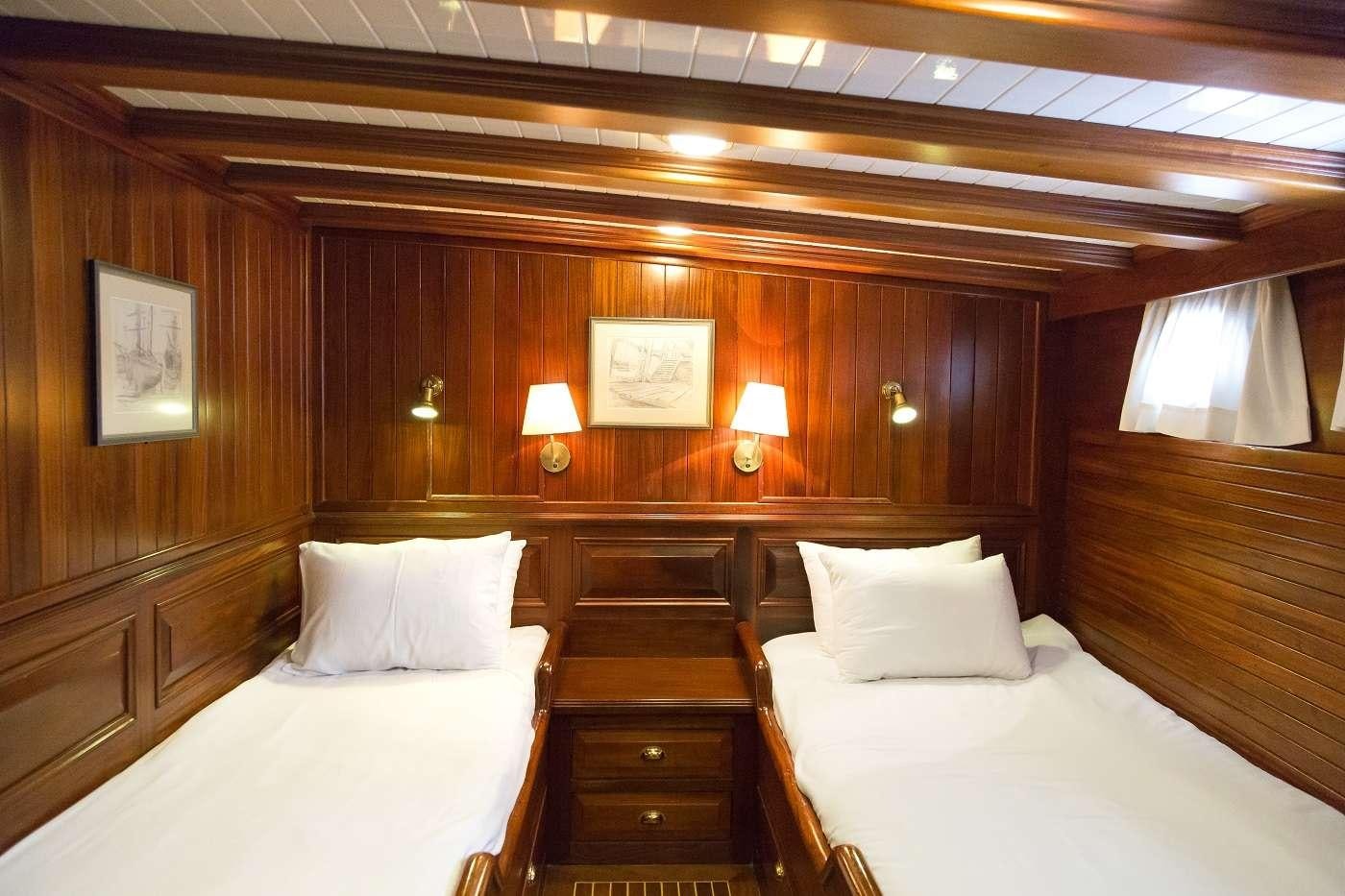 a room with two beds aboard ECCE NAVIGO Yacht for Charter