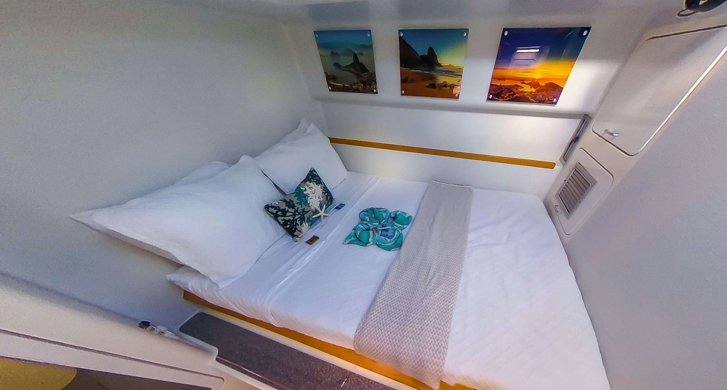 a bed with white sheets and pillows aboard YES DEAR Yacht for Charter