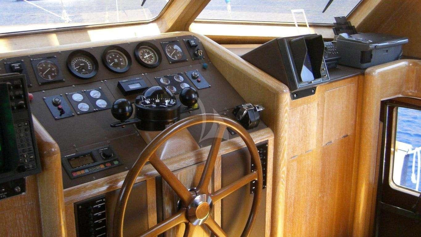 a wooden desk with a radio and radio aboard ALTHEA Yacht for Charter