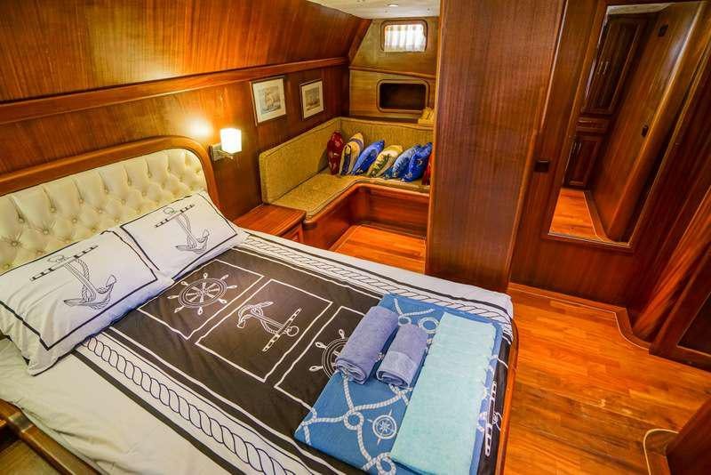 a bedroom with a bed and a desk aboard GOLDEN PRINCESS Yacht for Charter
