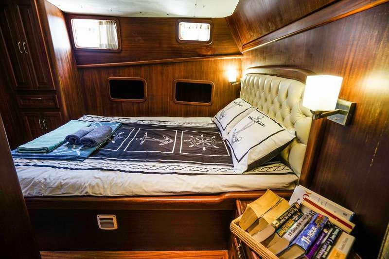 a bed with a blue comforter aboard GOLDEN PRINCESS Yacht for Charter