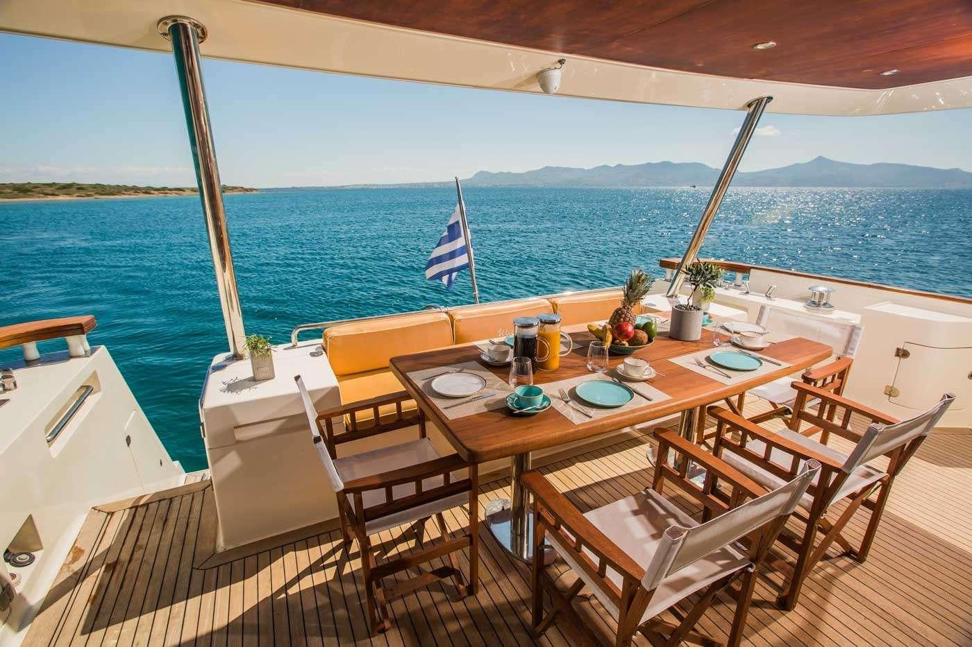 a table set for a meal on a balcony overlooking the ocean aboard ULISSE Yacht for Charter