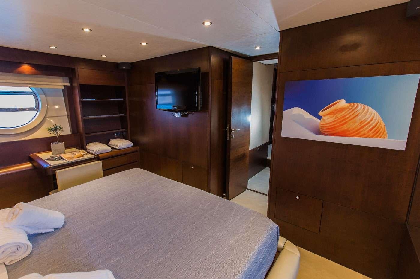 a room with a bed and tv aboard ULISSE Yacht for Charter