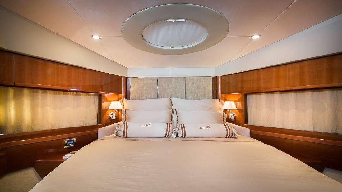 a large bed with a white pillow aboard Anna Wo Yacht for Charter