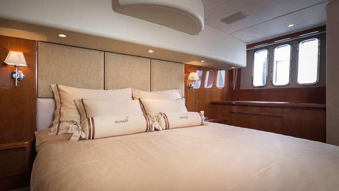 a bed with a white comforter aboard Anna Wo Yacht for Charter