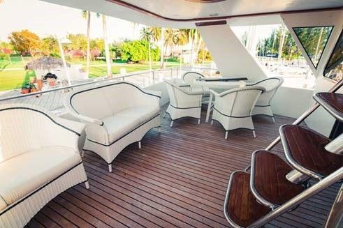a deck with a table and chairs aboard ATLANTIS II Yacht for Charter