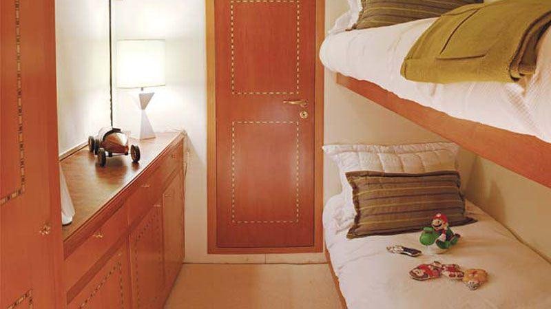 a bedroom with a bed and a red door aboard ATLANTIS II Yacht for Charter