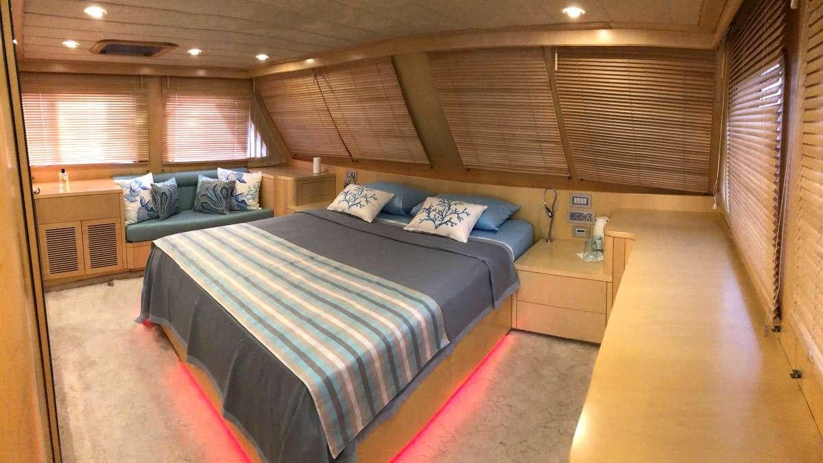 a room with a bed and a table aboard RIGEL Yacht for Charter