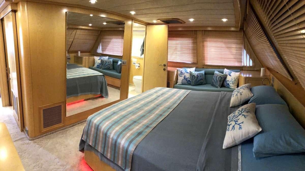 a room with a bed and a couch aboard RIGEL Yacht for Charter