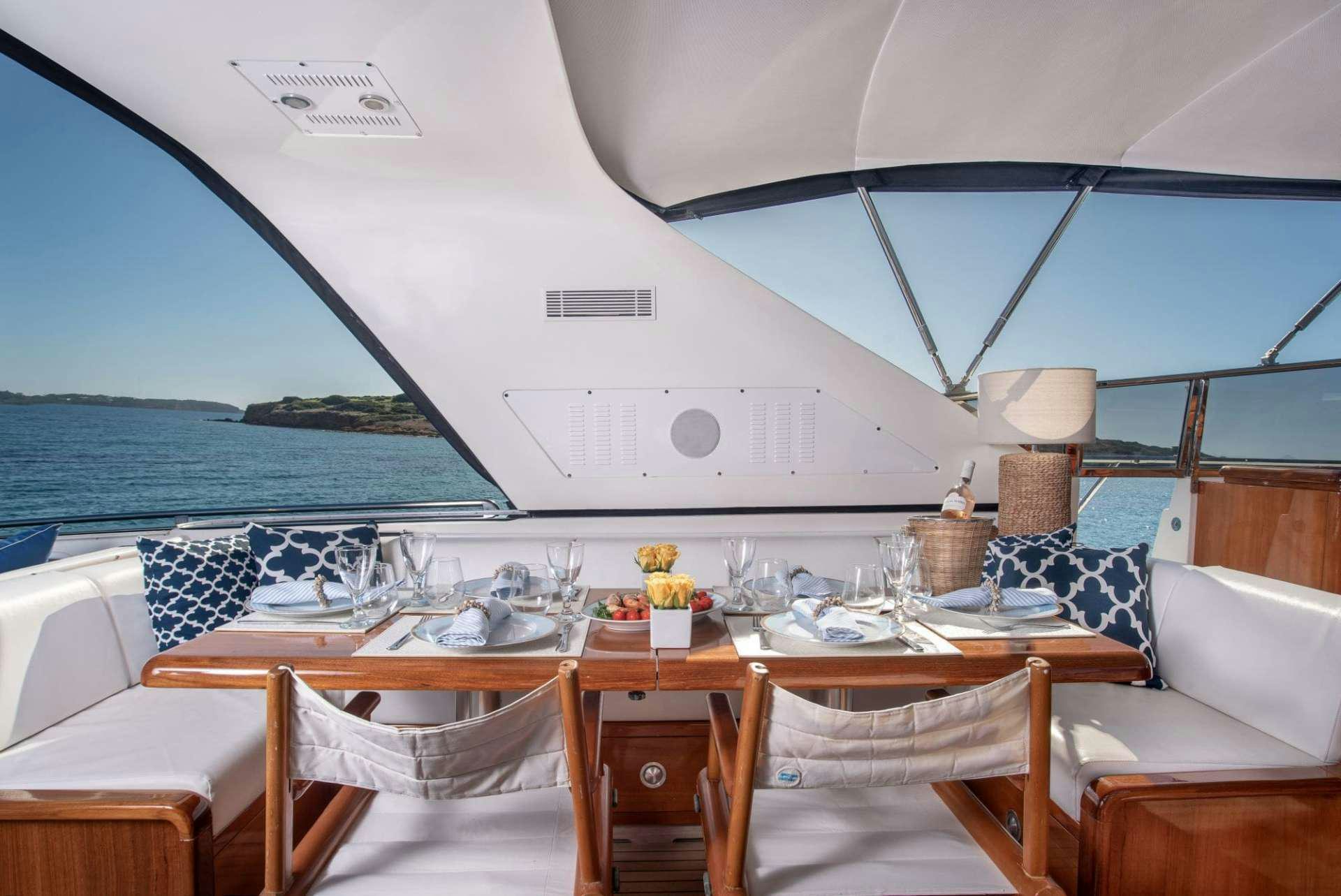 a table with chairs and a large umbrella on a boat aboard TURN ON Yacht for Charter