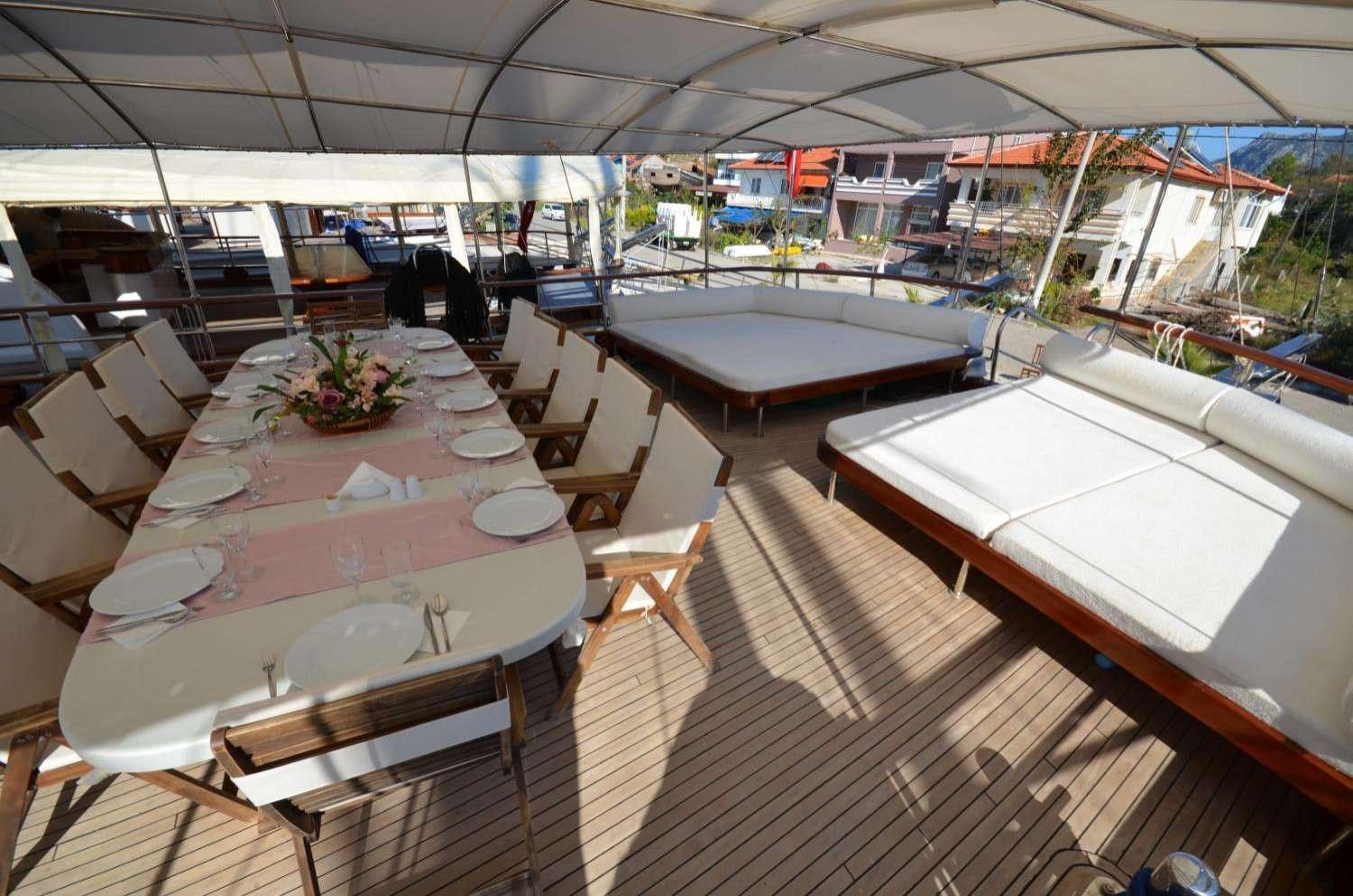a room with tables and chairs aboard Cagan Yacht for Charter