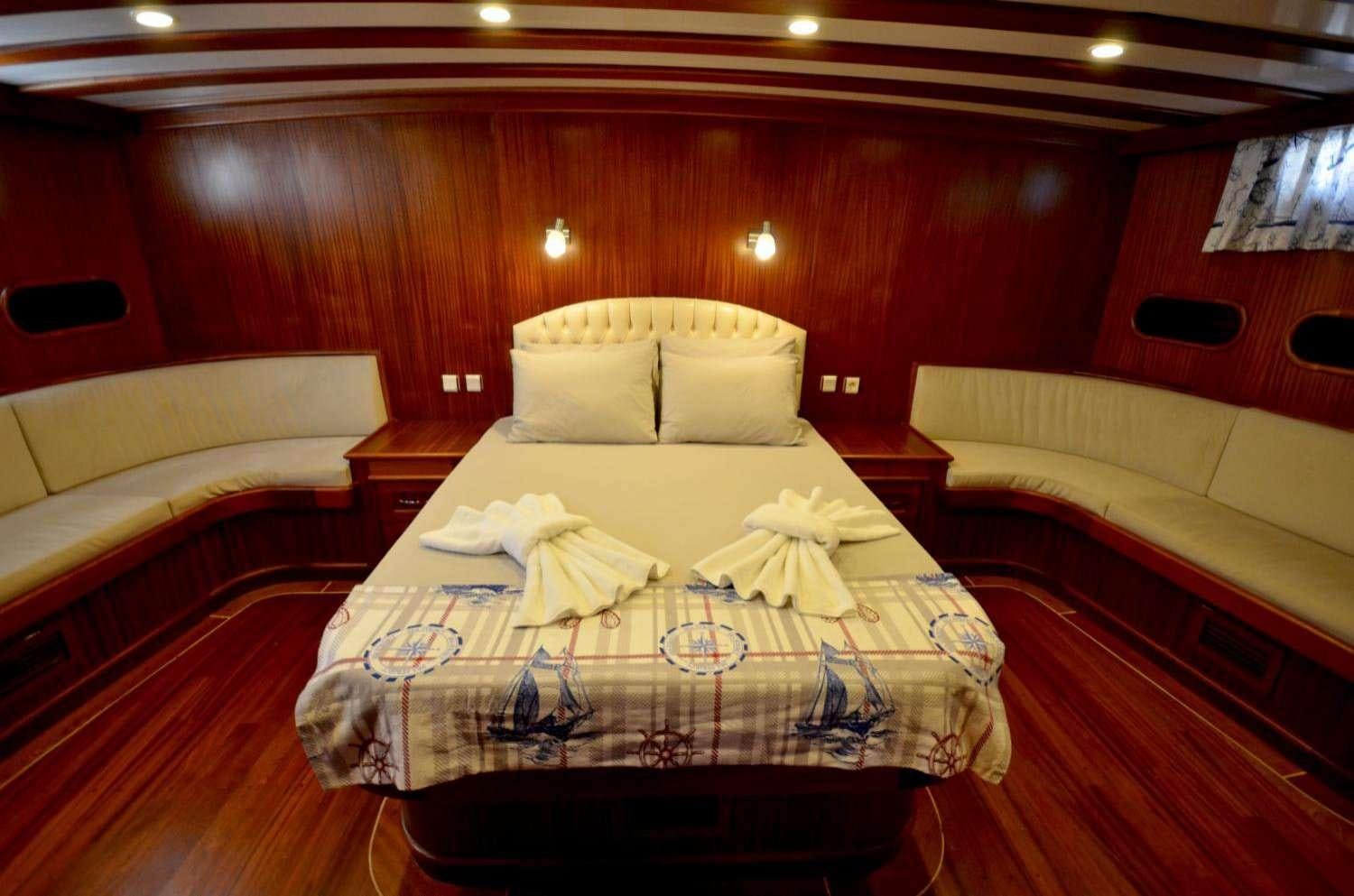 a room with beds and a red wall aboard Cagan Yacht for Charter