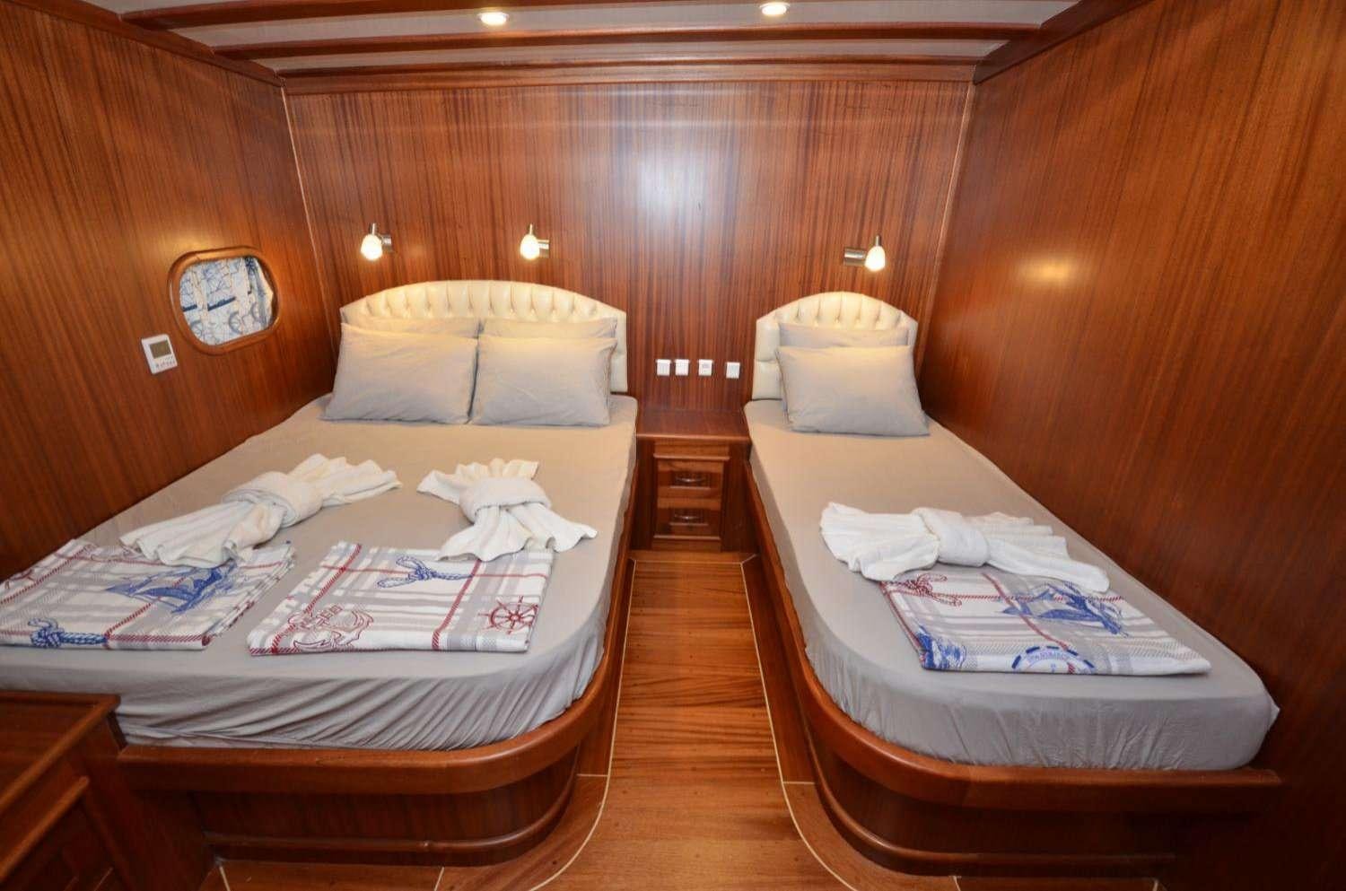 a couple of beds in a wooden room aboard Cagan Yacht for Charter