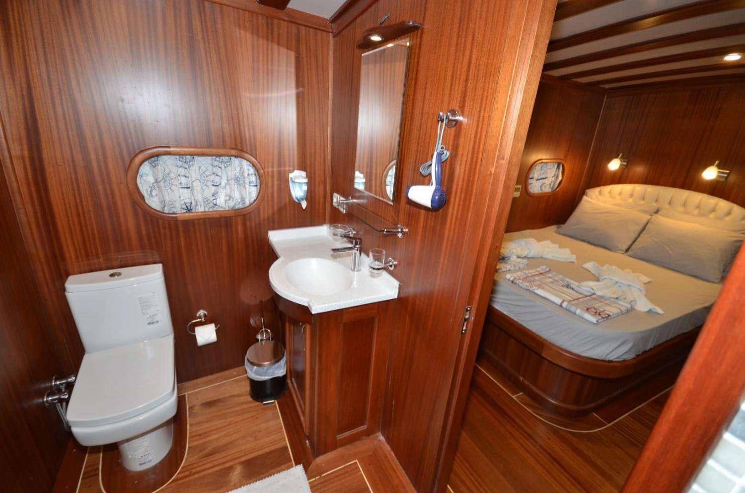 a bathroom with a sink and a bed aboard Cagan Yacht for Charter