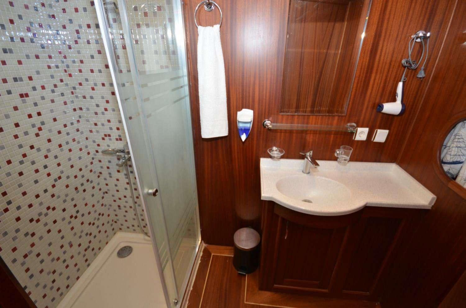 a bathroom with a sink and shower aboard Cagan Yacht for Charter