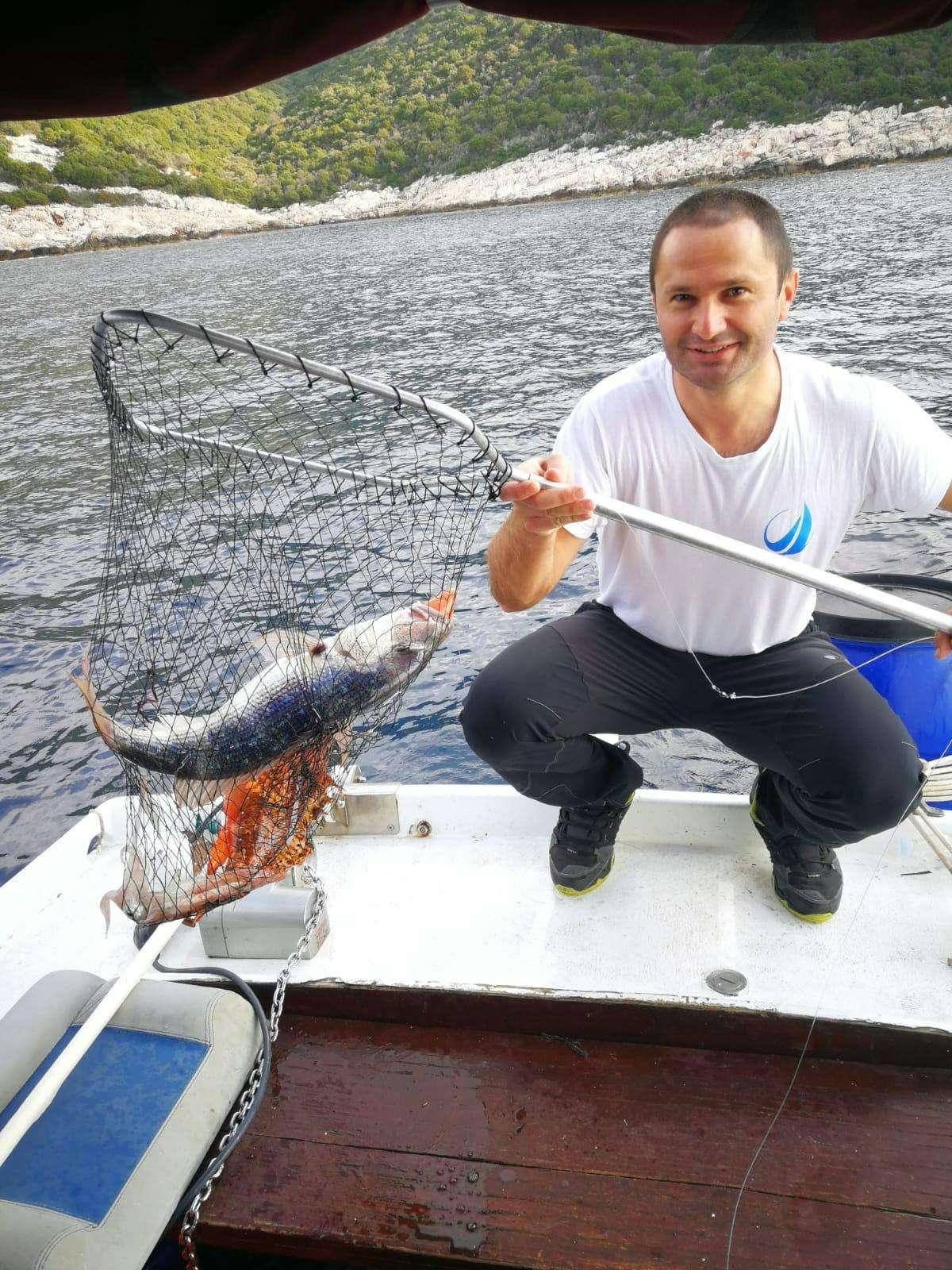 a person sitting on a boat holding a bird aboard ARCTIC QUEEN Yacht for Charter