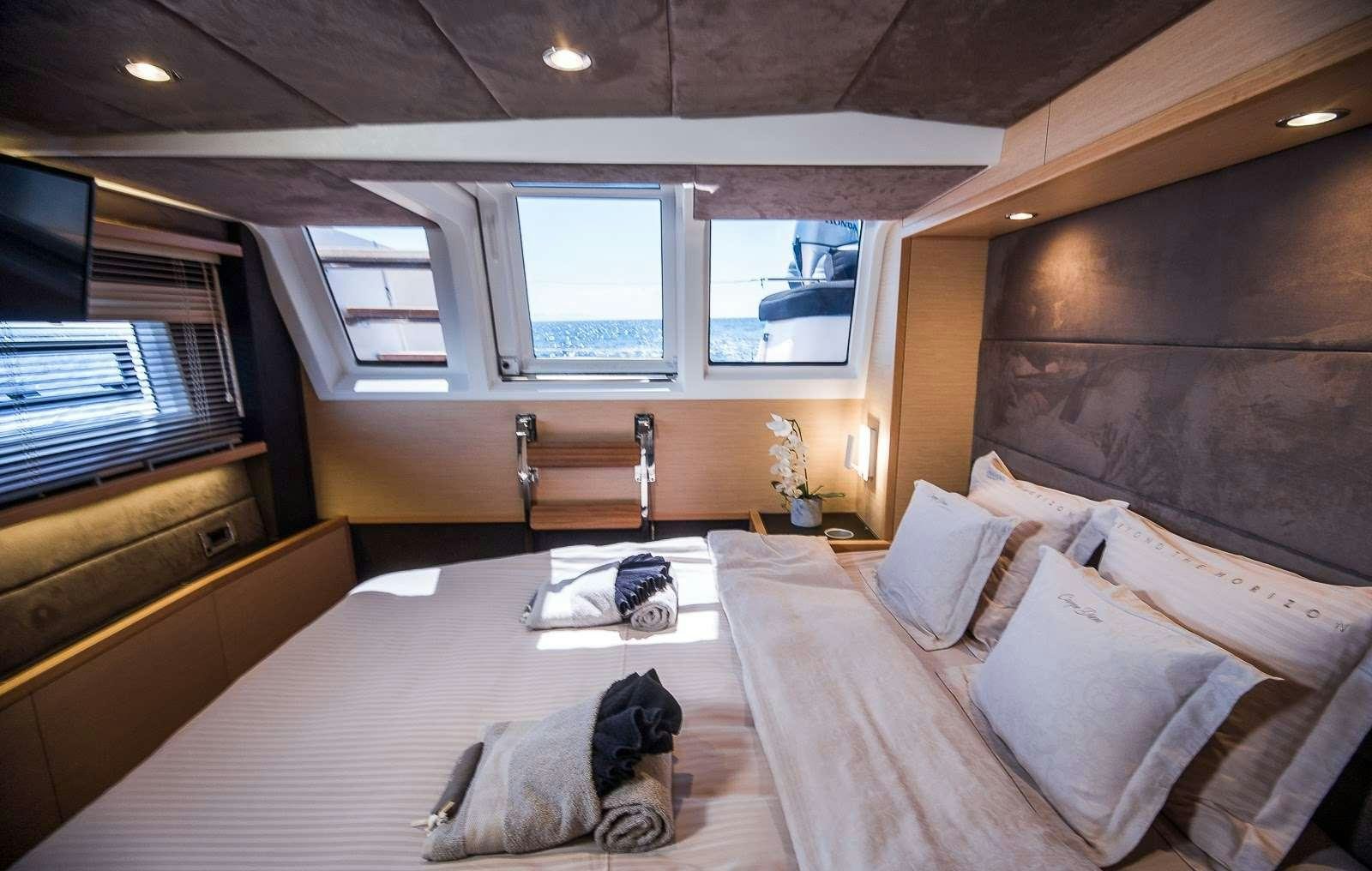 a bedroom with a bed and a window aboard CARPE DIEM Yacht for Charter