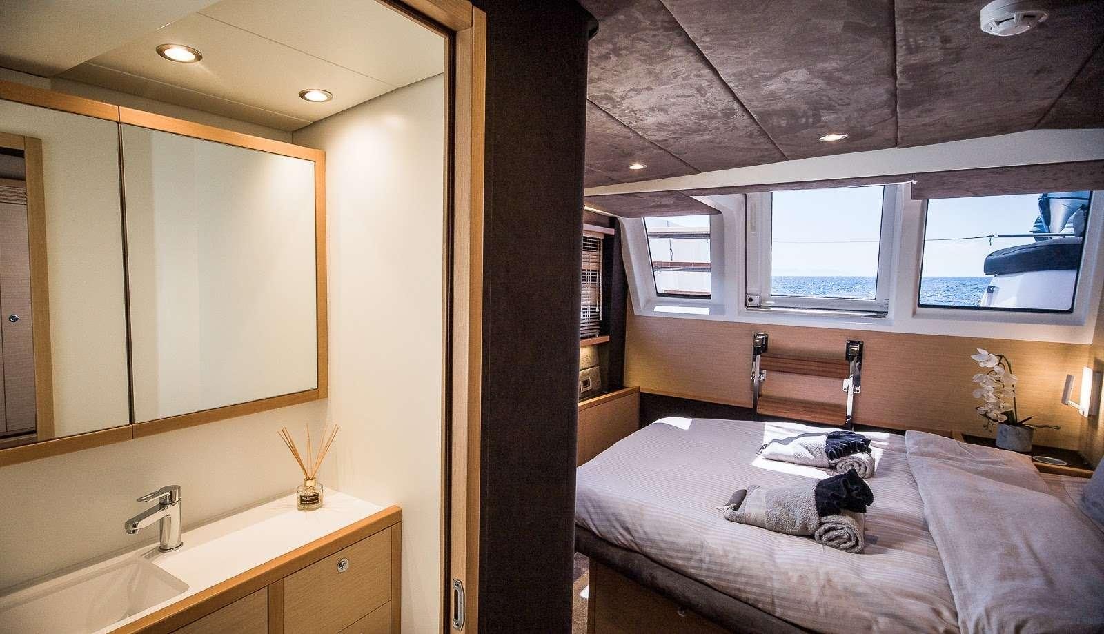 a bedroom with a bed and a mirror aboard CARPE DIEM Yacht for Charter