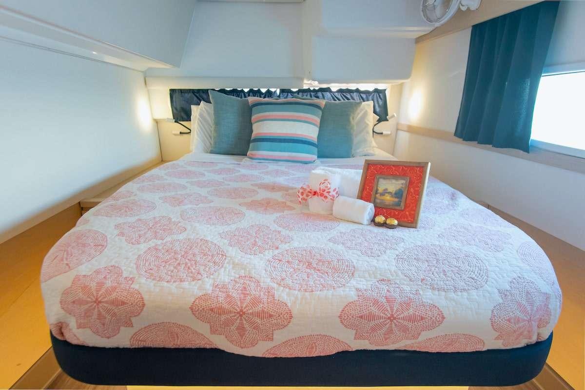 a bed with a pillow and flowers aboard EDDIES IN TIME Yacht for Charter