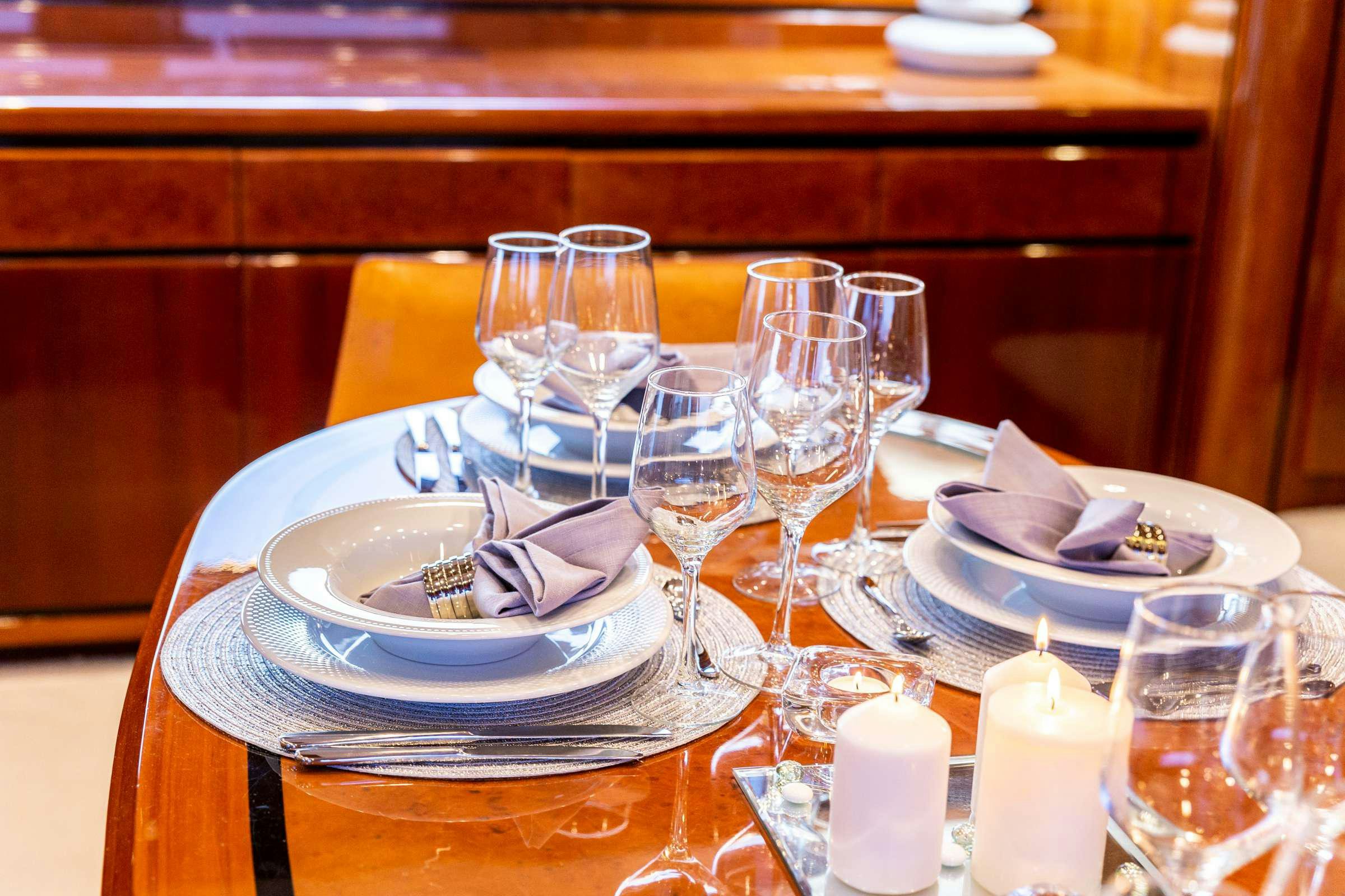 a table with plates and glasses aboard PAREAKI Yacht for Charter