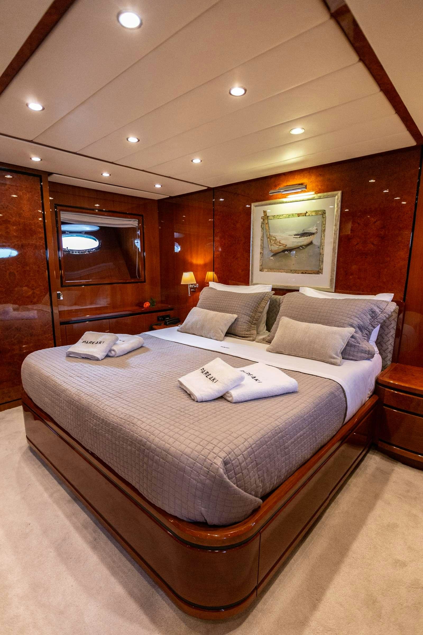 a bed with a large mirror above it aboard PAREAKI Yacht for Charter