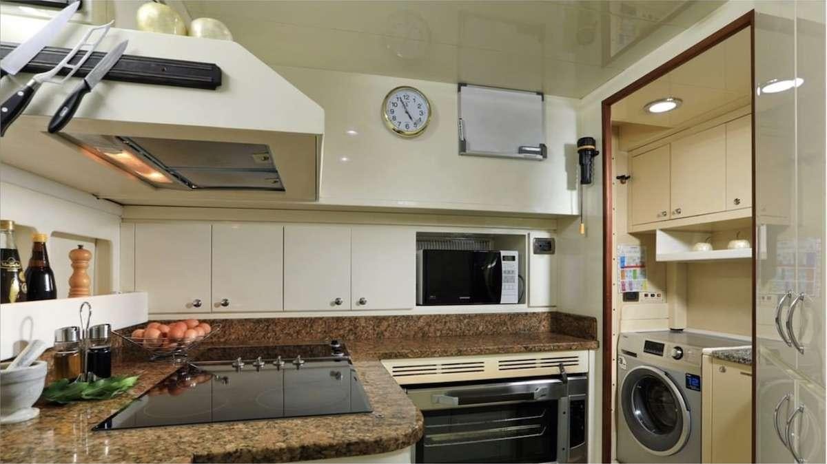 a kitchen with white cabinets aboard DEMAREST Yacht for Charter